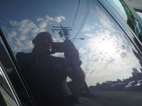1999 Ford Crown Victoria - Reflection of person and sky in the shiny surface of a car's hood.