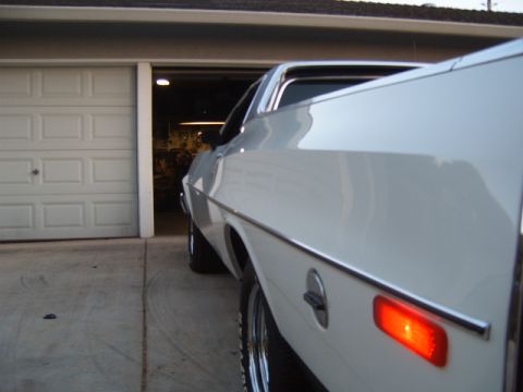 1973 Ford Ranchero - Rear three-quarter view of a white 1973 Ford Ranchero parked in front of a garage.