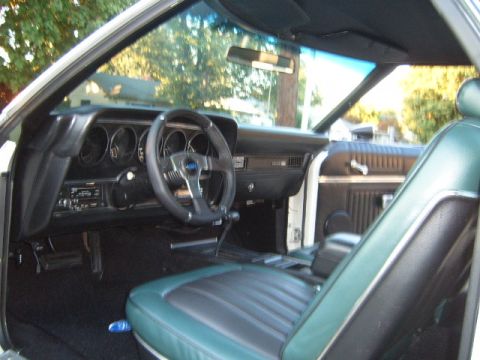 1973 Ford Ranchero - The interior of a 1973 Ford Ranchero shows green vinyl seats and a black dashboard.