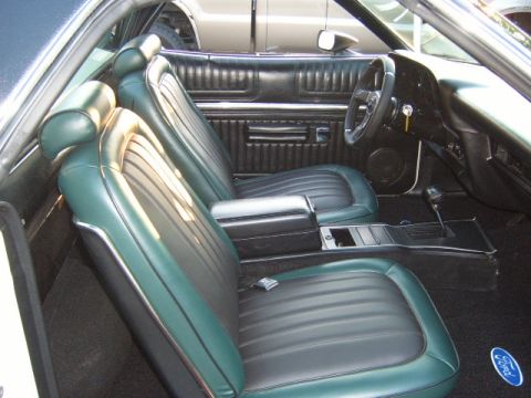1973 Ford Ranchero - The interior features two-tone green and black seats and a black dashboard with a steering wheel.