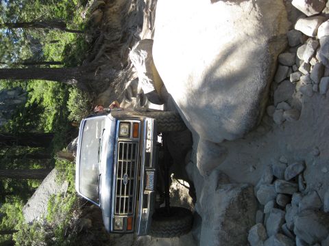 1986 Ford Bronco - Ford Bronco navigating a rocky trail, front grille visible. License plate reads PCCGH007.