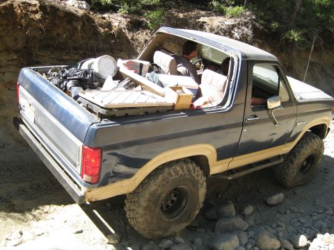 1986 Ford Bronco - Ford Bronco packed with supplies navigates a rough, rocky terrain.
