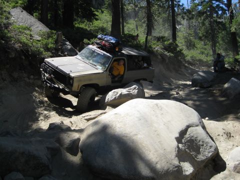1986 Ford Bronco - This vehicle is tackling a difficult off-road path with large rocks and steep inclines.
