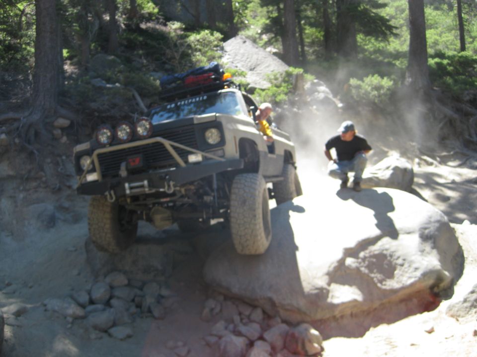 Off-road vehicle with custom bumper and lights climbing rocks