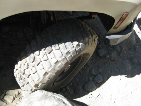 1986 Ford Bronco - A close-up view of a vehicle's tire navigating rocky terrain.