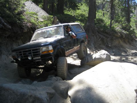 1986 Ford Bronco - Ford Bronco tackles a challenging off-road course with large rocks and steep inclines.