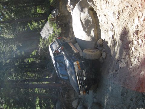 1986 Ford Bronco - This vehicle appears to be stuck on a difficult off-road trail, wedged between large rocks.