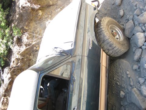 1986 Ford Bronco - A dark green Ford Bronco navigates a challenging rocky path.