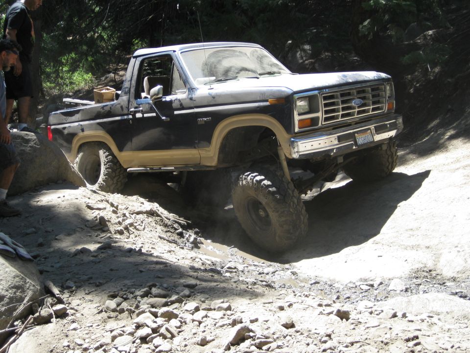 Dark blue and tan Ford Bronco off-roading on a rocky trail