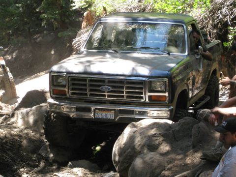 1986 Ford Bronco - This Ford F-Series truck, likely from the early 1980s, is shown off-roading over large rocks.
