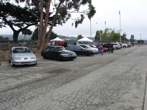 1992 Ford Taurus - Cars gathered at an outdoor event, including a 1992 Ford Taurus.