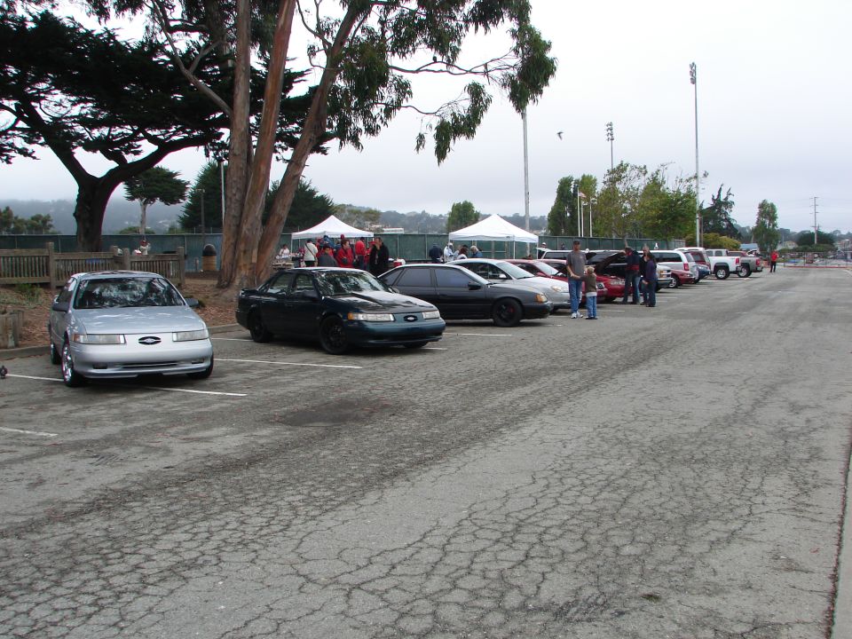 1992 Ford Taurus and other cars parked in a lot at an outdoor event
