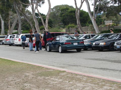 1992 Ford Taurus - 1992 Ford Taurus seen at a meet, parked in a lot with other cars and people around.