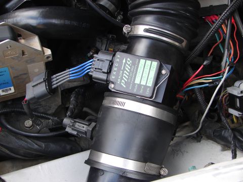 1992 Ford Taurus - Close-up view of an engine's air intake system, showing a mass airflow sensor and associated wiring.