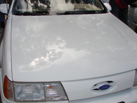 1992 Ford Taurus - Front view of a white 1992 Ford Taurus, identifiable by its grille and headlight design.