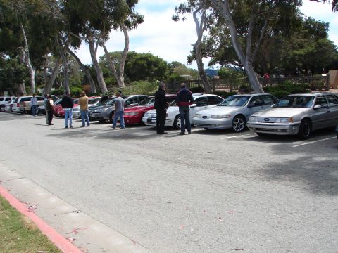 1992 Ford Taurus - Several cars are parked in a lot, including a silver 1992 Ford Taurus.