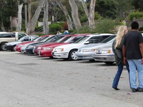 1992 Ford Taurus - A line of cars, including a silver 1992 Ford Taurus, are parked in a lot.