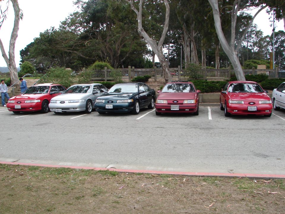 Five red and silver Ford Tauruses parked in a lot