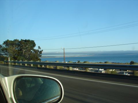 1992 Ford Taurus - View from a vehicle traveling along a scenic coastal highway with the ocean visible in the distance.