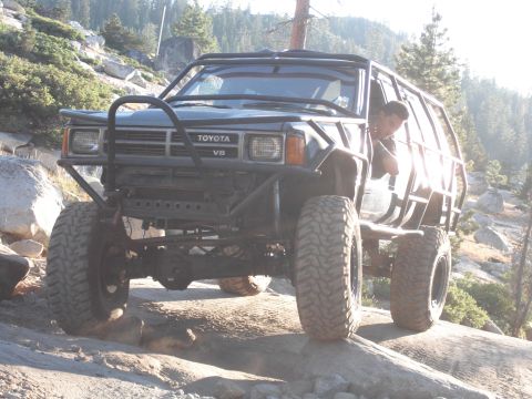 1991 Ford Bronco - This modified Toyota 4Runner is navigating a rocky trail with a driver visible inside.