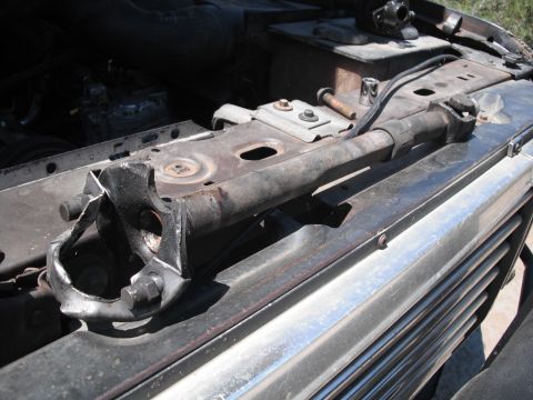 1991 Ford Bronco - The steering linkage appears bent and damaged, requiring repair or replacement.