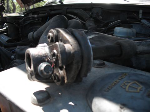 1991 Ford Bronco - A close-up view of the engine bay, focusing on a steering component and surrounding mechanical parts.