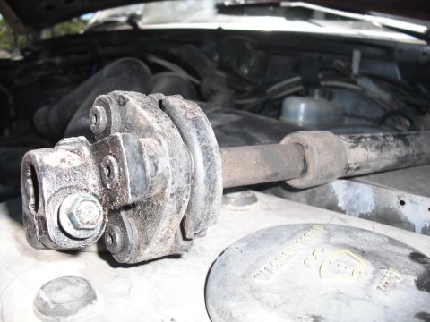 1991 Ford Bronco - Close-up of the steering shaft U-joint in the engine bay of a 1991 Ford Bronco.