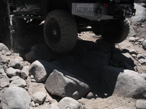 1991 Ford Bronco - Off-road vehicle navigating a rocky trail, California license plate visible.