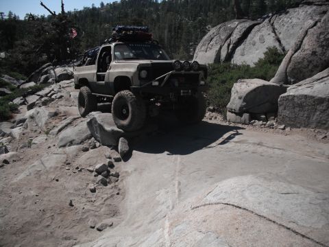 1991 Ford Bronco - This modified SUV tackles a challenging rocky trail, demonstrating its off-road capabilities.
