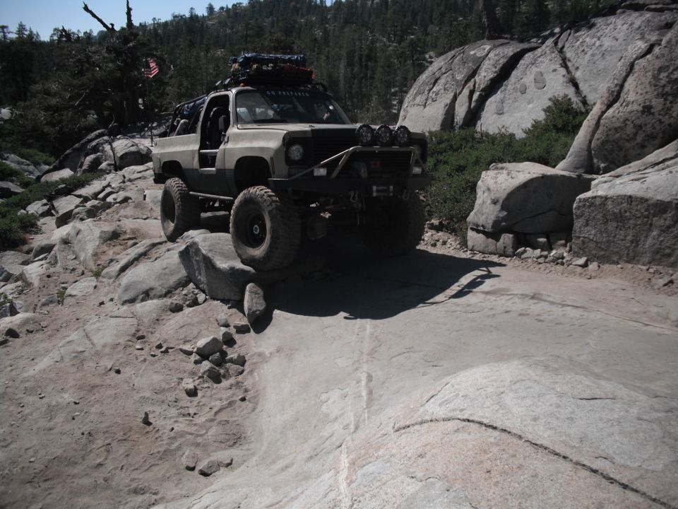Tan off-road SUV navigating rocky terrain