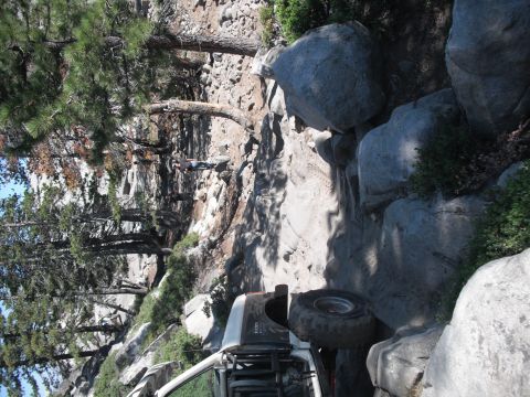 1991 Ford Bronco - An off-road vehicle navigates a challenging rocky terrain with steep inclines and large boulders.