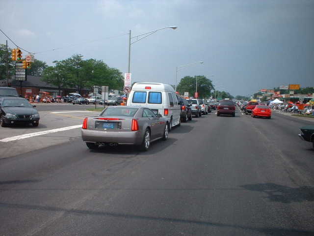 Silver coupe from rear, traffic on a sunny day