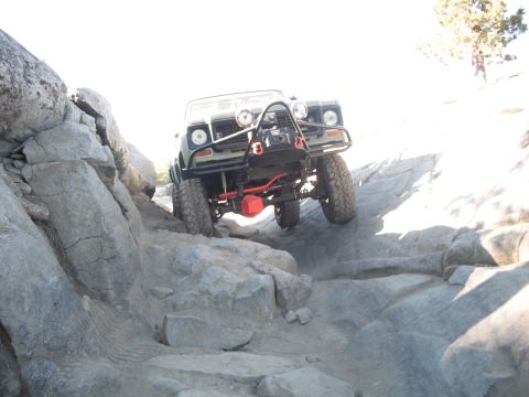 1991 Ford Bronco - An off-road vehicle navigates a challenging rocky trail, demonstrating its climbing capabilities.