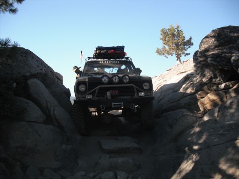 1991 Ford Bronco - This vehicle is carefully maneuvering through a tight, rocky canyon under a clear blue sky.