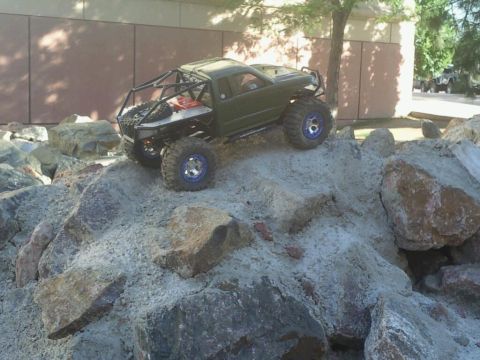 1996 Ford Bronco - This green remote control truck with a custom roll cage navigates a rocky terrain.