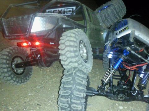 1996 Ford Bronco - Two RC rock crawlers are shown up close, highlighting their suspension and large off-road tires.