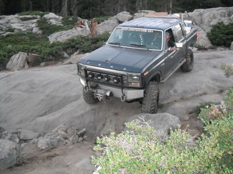 1991 Ford Bronco - This modified Ford truck navigates a challenging rocky trail, its off-road capabilities.