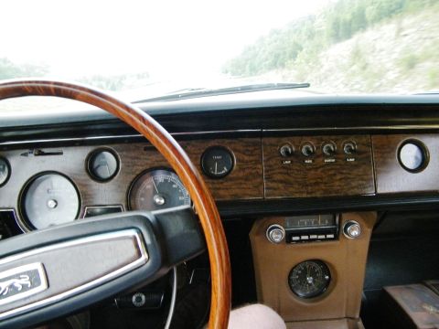 1968 Mercury Cougar - The interior of a 1968 Mercury Cougar shows a woodgrain dashboard with multiple gauges and a classic steering wheel.