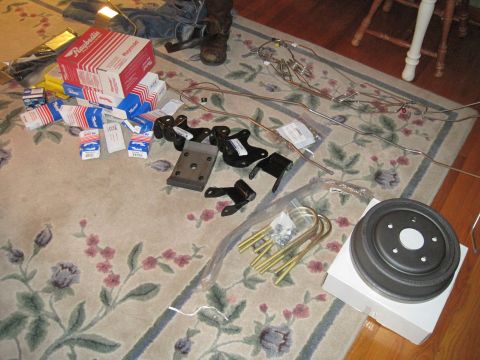 1979 Ford Bronco - Collection of vehicle suspension and brake parts laid out on a floral rug.