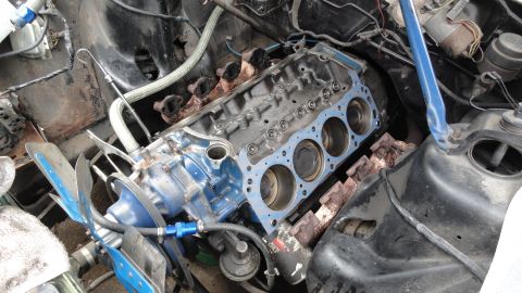 1964 Ford Fairlane - Close-up view of an engine block with pistons and a gasket, indicating internal engine work.