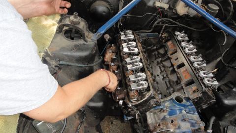 1964 Ford Fairlane - Close-up of engine valve train repair, showing exposed rocker arms and engine block.