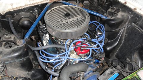 1964 Ford Fairlane - Close-up of a modified engine bay an Edelbrock air cleaner and bright blue spark plug wires.