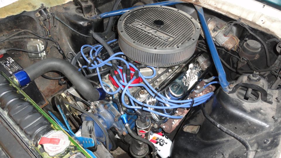 Engine bay with a Holley air cleaner and blue spark plug wires