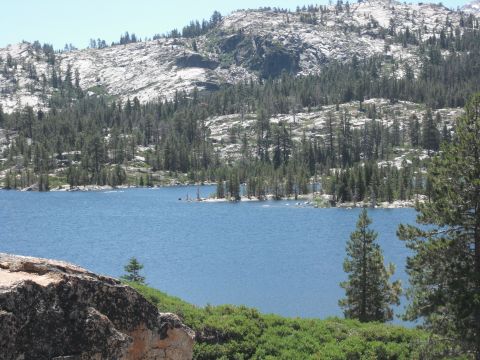 1991 Ford Bronco - A lake reflects the sky, bordered by dense pine forests and , rocky mountain slopes.