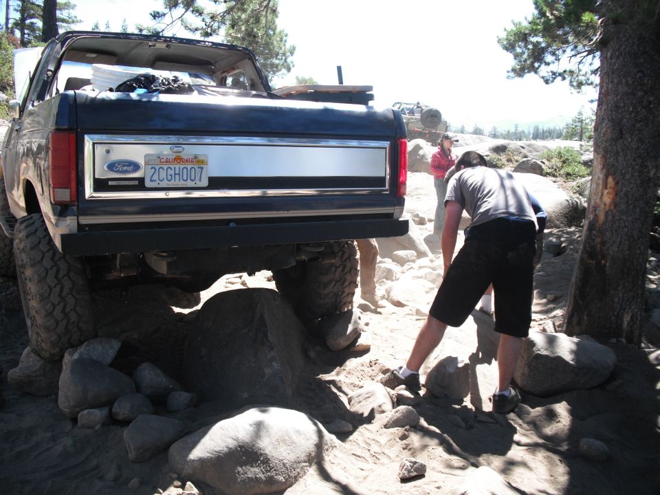 1987 Ford Bronco rear view on rocky terrain with people nearby