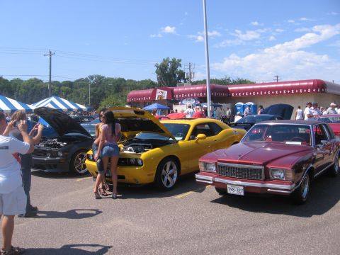 2001 Chevrolet Silverado 1500 - A maroon 1978 Chevrolet Monte Carlo is parked next to a yellow Dodge Challenger at a car show.