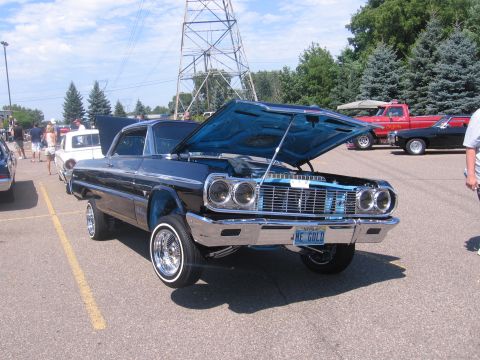 2001 Chevrolet Silverado 1500 - A classic lowrider Chevrolet Impala is displayed with its hood open, revealing the engine bay.