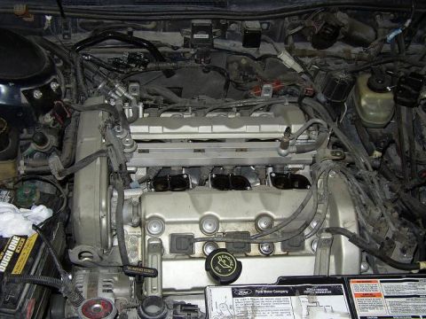 1993 Ford Taurus - Engine bay of a 1993 Ford Taurus SHO, showing the V6 engine and associated wiring and components.