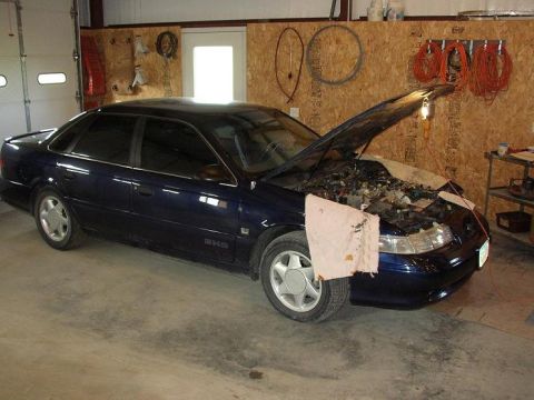 1993 Ford Taurus - Dark blue 1993 Ford Taurus SHO in a garage with the hood open.