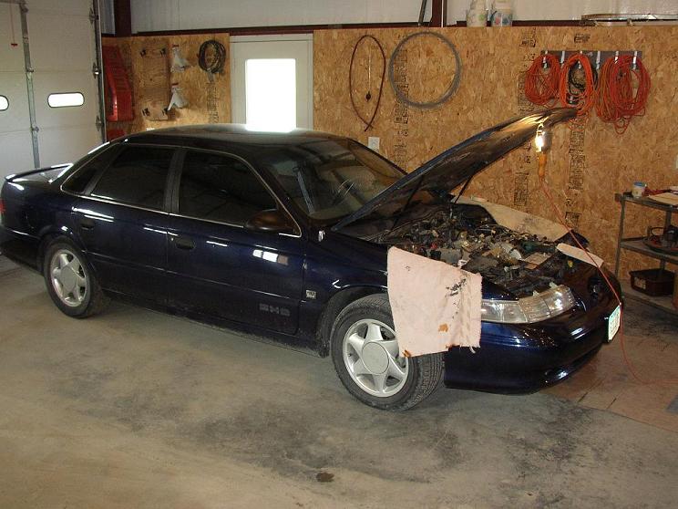 1993 Ford Taurus SHO in garage, hood open showing engine bay